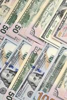 Many one hundred and fifty dollar bills on flat background surface close up. Flat lay top view photo
