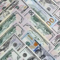 Many one hundred and fifty dollar bills on flat background surface close up. Flat lay top view photo