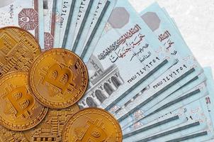 5 Egyptian pounds bills and golden bitcoins. Cryptocurrency investment concept. Crypto mining or trading photo