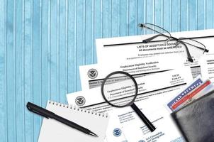 USCIS form I-9 Employment eligibility verification lies on flat lay office table and ready to fill. U.S. Citizenship and Immigration services paperwork concept photo