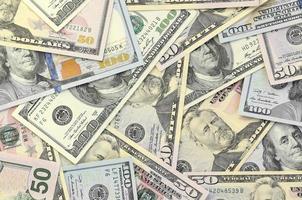 Many one hundred and fifty dollar bills on flat background surface close up. Flat lay top view photo