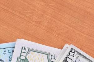 Stacks of many one hundred and fifty dollar bills on wooden background surface close up. Flat lay top view. Abstract business concept photo