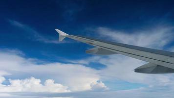 In Flight, Airplane Wing against Clouds and Blue Sky. Concept airplane travel video