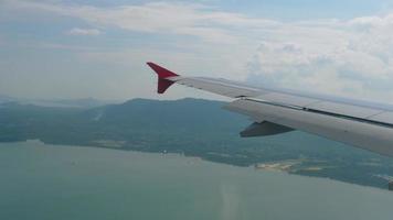 l'avion descendant avant l'atterrissage à l'aéroport de phuket, vue depuis le hublot de l'avion. video