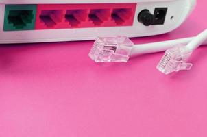 Internet router and Internet cable plugs lie on a bright pink background. Items required for Internet photo