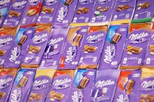 KHARKOV, UKRAINE - DECEMBER 8, 2020 Many wrappings of purple Milka chocolate. Milka is a Swiss brand of chocolate confection manufactured by company Mondelez International photo