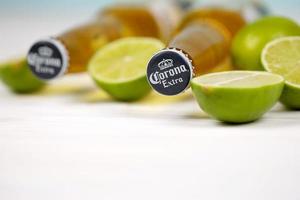 KHARKOV, UKRAINE - DECEMBER 9, 2020 Bottles of Corona Extra Beer with lime slices. Corona produced by Grupo Modelo with Anheuser Busch InBev most popular imported beer in the US photo