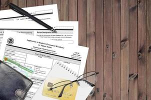 USCIS form I-485 Application to register permanent residence or adjust status lies on flat lay office table and ready to fill. U.S. Citizenship and Immigration services paperwork concept photo