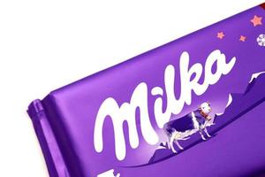 KHARKOV, UKRAINE - DECEMBER 8, 2020 Logo on Purple Milka chocolate on white. Milka is a Swiss brand of chocolate confection manufactured internationally by company Mondelez International photo