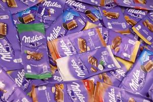 KHARKOV, UKRAINE - DECEMBER 8, 2020 Many wrappings of purple Milka chocolate. Milka is a Swiss brand of chocolate confection manufactured by company Mondelez International photo