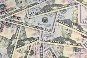 Many US fifty dollar bills on flat background surface close up. Flat lay top view. Abstract business concept photo
