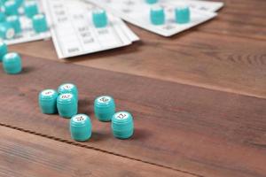 Many barrels with numbers and cards for lotto or russian bingo table game on wooden surface. Russian lotto has similar rules to classical worldwide bingo photo