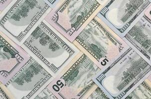 Many one hundred and fifty dollar bills on flat background surface close up. Flat lay top view photo