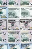 Many one hundred and fifty dollar bills on flat background surface close up. Flat lay top view photo