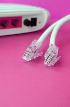 Internet router and Internet cable plugs lie on a bright pink background. Items required for Internet photo