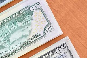 Stacks of many one hundred and fifty dollar bills on wooden background surface close up. Flat lay top view. Abstract business concept photo