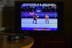 kharkov, ucrania - 12 de noviembre de 2020 controlador de videojuegos sega mega drive en la mesa con el juego wrestlemania en exhibición foto