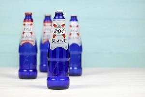 kharkov, ucrania - 8 de diciembre de 2020 logotipo blanco en botellas de cerveza en mesa blanca. 1664 blanc es la cerveza de trigo de la cervecería francesa kronenbourg exportada a todo el mundo foto