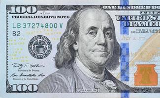 Portrait of US president Benjamin Franklin on 100 dollars banknote closeup macro fragment. United states hundred dollars money bill photo