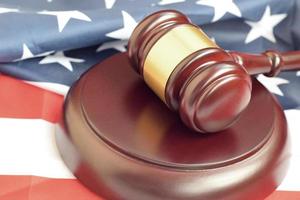 Justice mallet on United States flag in a courtroom during a judicial trial. Law concept and empty copyspace. Judge hammer photo