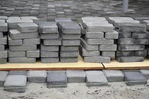 Rows of gray and dark grey walkway slab lying outdoors. Material for Paving Slabs by mosaic in progress. Cobblestone installation photo
