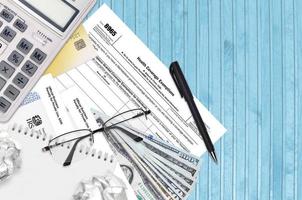 IRS form 8965 Health Coverage Exemptions lies on flat lay office table and ready to fill. U.S. Internal revenue services paperwork concept. Time to pay taxes in United States photo
