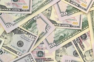 Many US fifty dollar bills on flat background surface close up. Flat lay top view. Abstract business concept photo