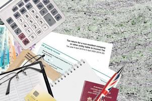 English form sa700 Tax return for a non-resident company or other entity liable to income tax from HM revenue and customs lies on table with office items. HMRC paperwork photo