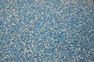 Texture of a colored granular sand close up. Blue grains photo