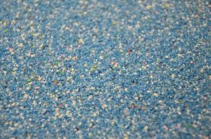 Texture of a colored granular sand close up. Blue grains photo