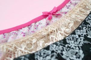 White, black and pink women underwear with lace on pink background with copy space. Advertising for shop of beautiful and comfortable women underwear photo