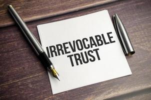 Irrevocable trust text on white sticker and pen photo