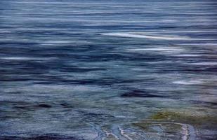 Winter background of the icy surface of the river. Texture of ice covered with snow. photo