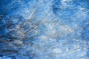 Winter background of the icy surface of the river. Texture of ice covered with snow. photo
