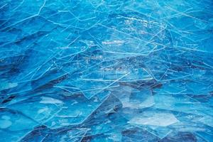 Winter background of the icy surface of the river. Texture of ice covered with snow. photo