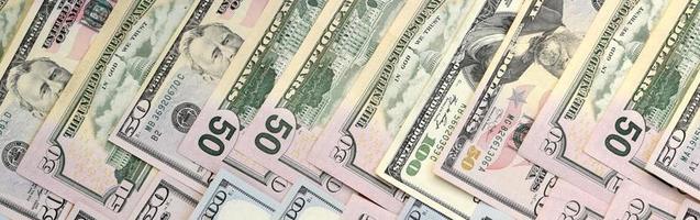 Many one hundred and fifty dollar bills on flat background surface close up. Flat lay top view photo