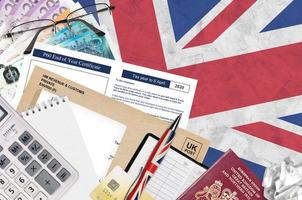 English Tax form P60 End of year certificate by HM revenue and customs lies on table with office items. HMRC paperwork and tax paying process in United Kingdom photo