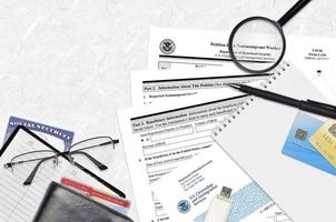 USCIS form I-129 Petition for a nonimmigrant worker lies on flat lay office table and ready to fill. U.S. Citizenship and Immigration services paperwork concept photo