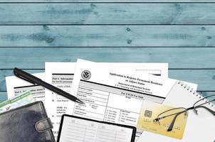 USCIS form I-485 Application to register permanent residence or adjust status lies on flat lay office table and ready to fill. U.S. Citizenship and Immigration services paperwork concept photo