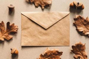 Autumn flat lay, fall background with kraft paper envelope and oak leaves photo