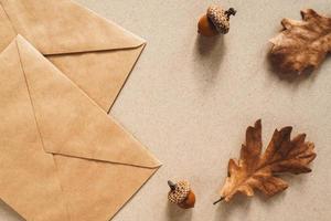 Fall background with kraft paper envelope and oak leaves, autumn flat lay, copy space photo