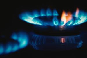 Gas flame, stove top cooker blue orange fire in the dark, copy space photo