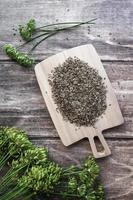 Dill seeds and flowers, Anethum graveolens on wooden background, overhead flat lay, vertical frame photo