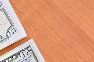 Stacks of many one hundred and fifty dollar bills on wooden background surface close up. Flat lay top view. Abstract business concept photo