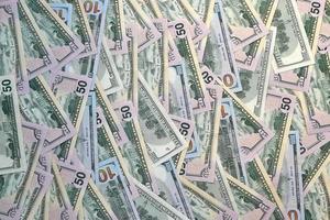 Many one hundred and fifty dollar bills on flat background surface close up. Flat lay top view photo