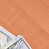 Stacks of many one hundred and fifty dollar bills on wooden background surface close up. Flat lay top view. Abstract business concept photo