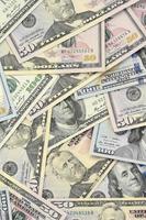 Many one hundred and fifty dollar bills on flat background surface close up. Flat lay top view photo