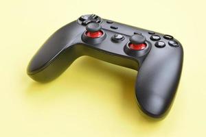 Modern black video game controller on yellow background. Online video game players community concept photo