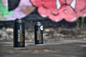 Used Montana black aerosol spray cans against graffiti paintings. MTN or Montana-cans is manufacturer of high pressure spray paint goods photo