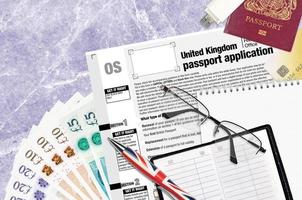 English form OS United Kingdom passport application from HM passport office lies on table with office items. UK passport paperwork photo